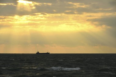 Gün batımında ufukta teknesi olan güzel bir deniz manzarası. seyahat arkaplanı