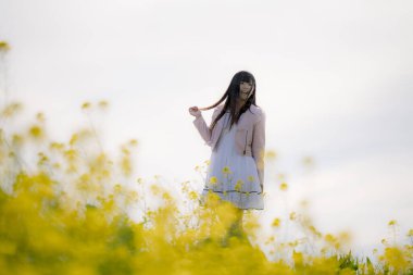 Güzel Asyalı kadın bahçede poz veriyor. 