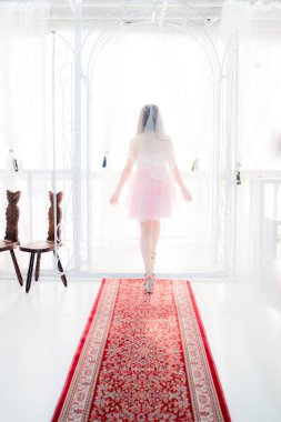 Beyaz elbiseli genç bir kadının arka görüntüsü.