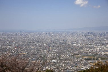 Gündüz vakti bulutlu gökyüzü altındaki modern Japon şehrinin havadan görünüşü 