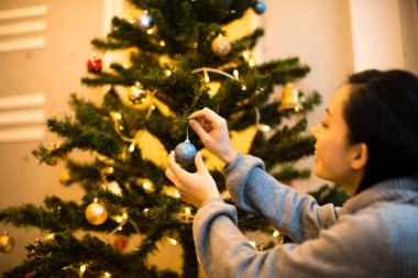 Genç ve güzel bir kadın Noel ağacının yanında arka planda 