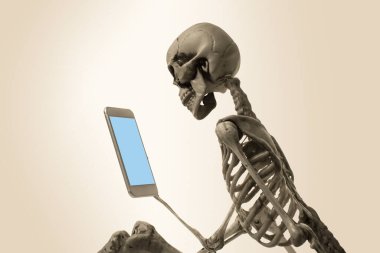 Elinde cep telefonu tutan korkunç iskelet. Cadılar Bayramı konsepti