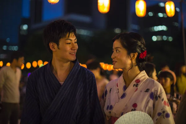 young Japanese couple wearing traditional kimono in evening park