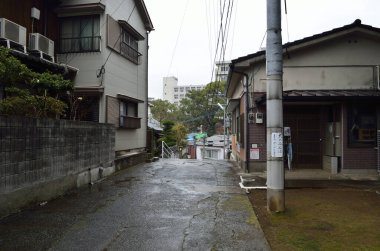 Japonya 'da dar asfaltlı cadde, hafif bir meyilli, konut binaları tarafından çevrili..