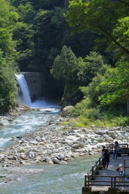 Dağ vadisinde güneşi yansıtan hızlı nehir.