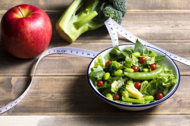 diyet ve sağlıklı gıda konsepti. Taze salata, sebze ve mezura..