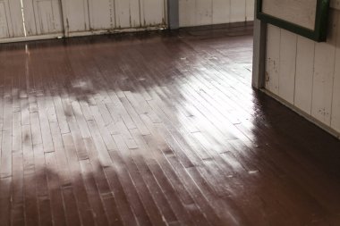 Parlak, temiz zemini olan eski ahşap bir evin iç manzarası.