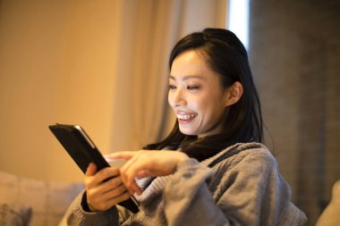 Evinde tableti olan güzel bir kız. 