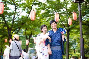 Geleneksel kimono giyen ve parkta yürüyen genç bir Japon çift.