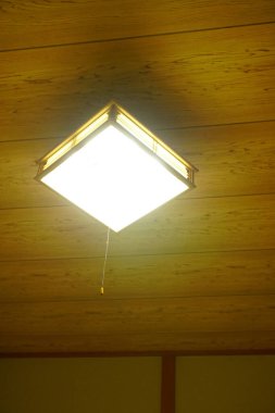 Ahşap tavan arkaplanındaki kare lamba.