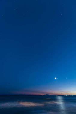 Gece gökyüzü yıldızlarla ve ayın üzerinde 