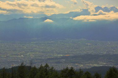 Dağlık vadideki kasabanın manzarası ve mavi gökyüzündeki bulutlar.