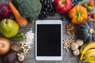 Taze meyve ve sebzelerle çevrili tablet