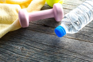 Dambıl görüntüsü, bir şişe su ve ahşap arka planda havlu. sağlıklı yaşam tarzı kavramı           