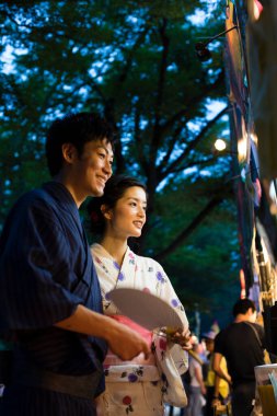Akşam parkında geleneksel kimono giyen genç Japon çift.