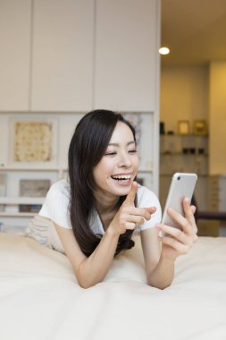 Genç ve güzel bir kadın telefonunu kullanıyor. 