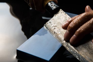 Bıçağı keskinleştiren kişinin ellerinde yakın çekim görüntüsü