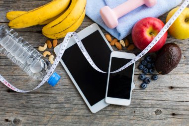 Dambıl, bir şişe su, mezuralar, ahşap zemin üzerindeki meyveler. sağlıklı yaşam tarzı kavramı           