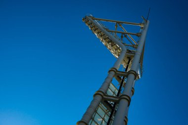 Açık mavi gökyüzüne karşı modern stadyum projektör kulesi