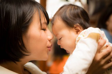 Asyalı anne kız öpüşüyor.