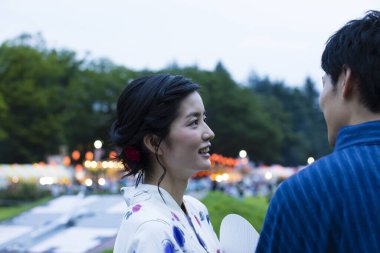 Geleneksel kimono giyen ve parkta yürüyen genç bir Japon çift.