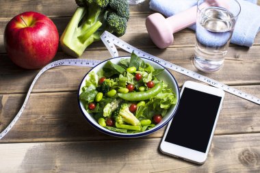 Dambıl, akıllı telefon, mezura ve organik yiyecekler. sağlıklı yaşam tarzı kavramı           