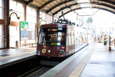 Japon şehrinde gündüz görüşü olan kalabalık treni olan eski tren istasyonu. 