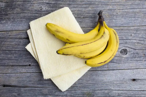 Bananen Und Handtuch Auf Einem Holztisch — Stockfoto