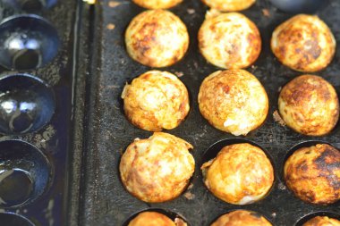 Takoyaki, top şeklinde Japon aperatifleri un bazlı hamurdan yapılmış ve özel kalıplı bir tavada pişirilmiş..