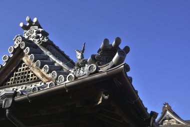 Mavi gökyüzü arka planındaki Japon tapınağının çatısı.