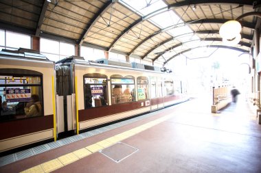 Japon şehrindeki istasyonda insanlarla dolu eski tren.