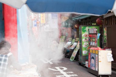 Meşgul Asya pazarında dumanı tüten sokak yemekleri standı