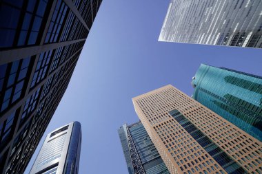 Modern şehir mimarisi, Tokyo, Japonya. Gökdelenler mavi gökyüzüne karşı güneşli bir günde 