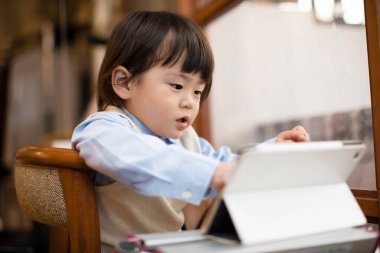 Tabletli küçük Asyalı çocuğun portresi