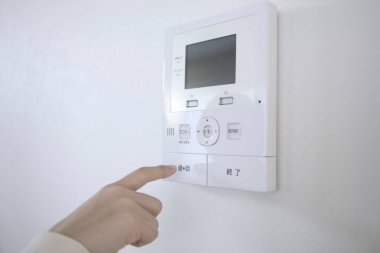 Erkek eli beyaz duvarda iklim kontrolüne dokunuyor