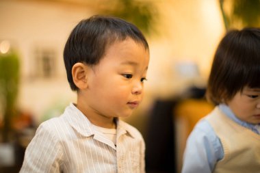 Odadaki sevimli Asyalı çocukların portresi.