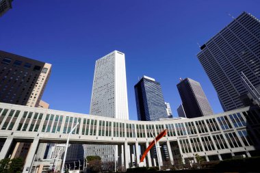 Modern şehir mimarisi, Tokyo, Japonya. Gökdelenler mavi gökyüzüne karşı güneşli bir günde 