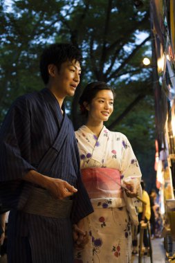 Akşam parkında geleneksel kimono giyen genç Japon çift.