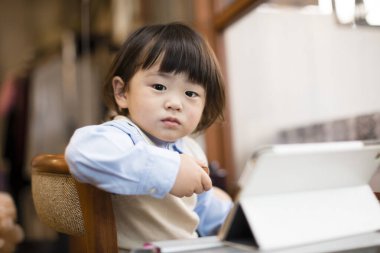 Tabletli küçük Asyalı çocuğun portresi