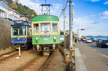 Hareket eden tramvayların yer aldığı sokak fotoğrafı.