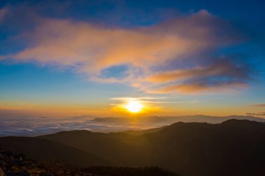 Sisli dağların üzerinde güzel gün batımı