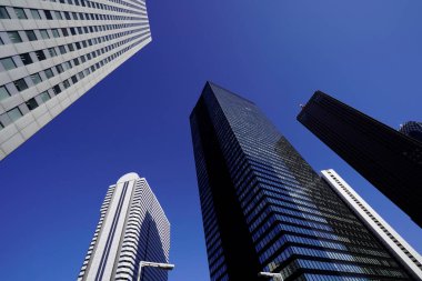 Modern şehir mimarisi, Tokyo, Japonya. Gökdelenler mavi gökyüzüne karşı güneşli bir günde 