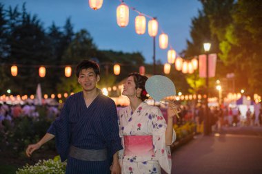 Akşam parkında geleneksel kimono giyen genç Japon çift.