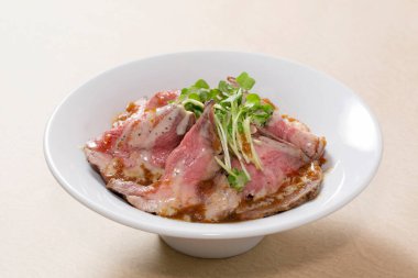 Tabakta çiğ et olan bir mutfak fotoğrafı. 