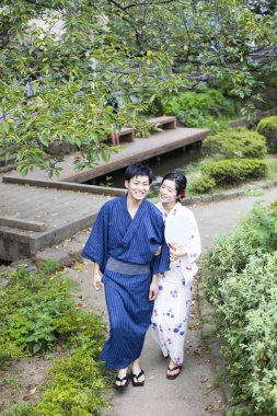 Genç Japon çift yaz parkında geleneksel kimono giyiyor.