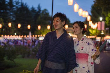 Akşam parkında geleneksel kimono giyen genç Japon çift.