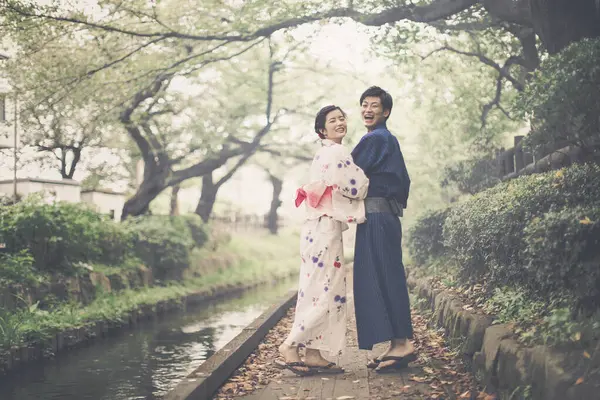 young Japanese couple wearing traditional kimono in summer park