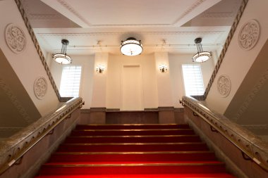 Kırmızı merdivenleri olan modern bir binanın içinde. 