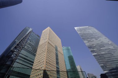 Modern şehir mimarisi, Tokyo, Japonya. Gökdelenler mavi gökyüzüne karşı güneşli bir günde 