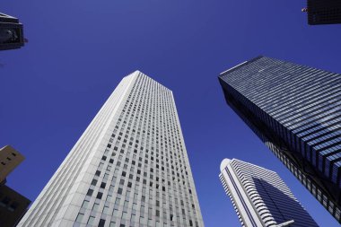 Modern şehir mimarisi, Tokyo, Japonya. Gökdelenler mavi gökyüzüne karşı güneşli bir günde 